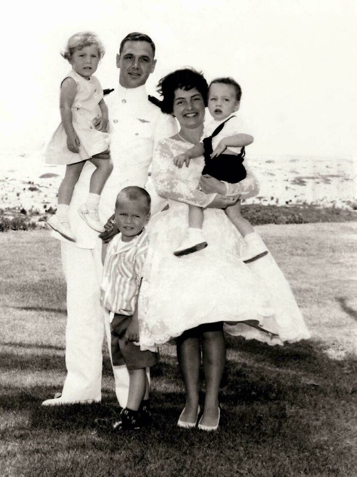 Vintage family photo of a couple with three children, smiling outdoors, capturing a beautiful moment from the past.