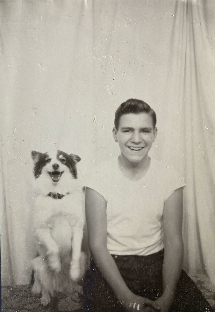 Joven sonriente junto a su perro feliz en foto en blanco y negro vintage, imagen elocuente de décadas pasadas.