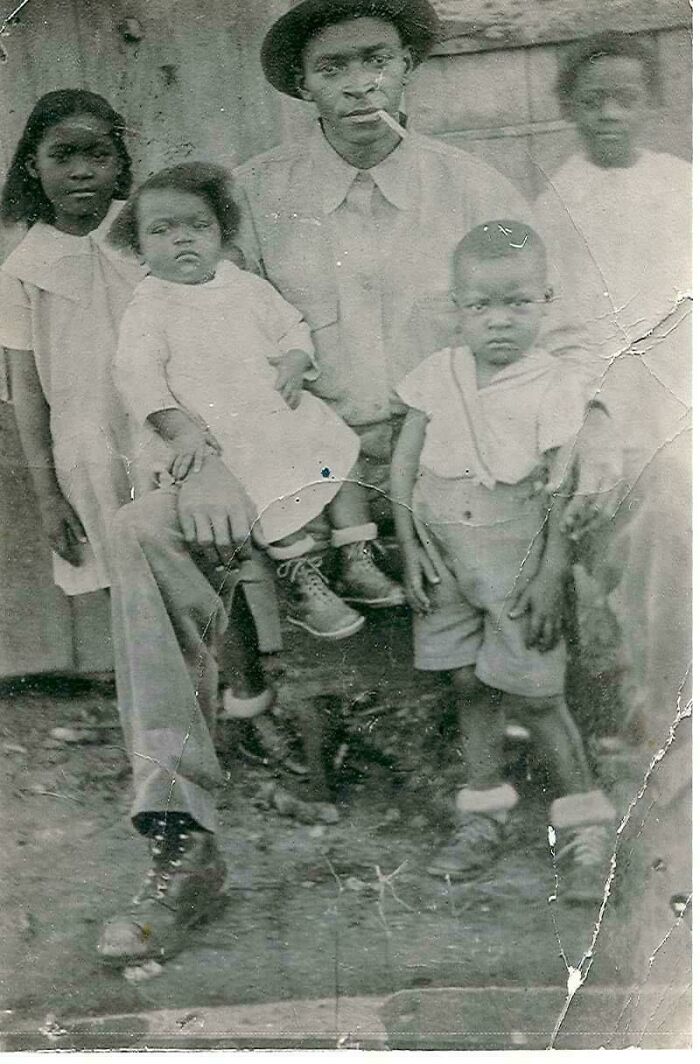 A vintage family photo capturing a father with his children in an outdoor setting, evoking beautiful past memories.