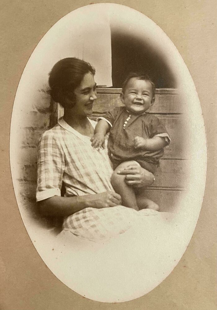 A mother and child smiling in an old black-and-white photograph, highlighting beautiful and interesting moments from the past.