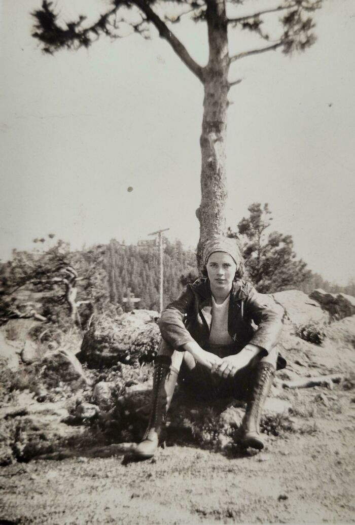 Mujer sentada bajo un árbol en paisaje natural vintage, foto de hace décadas que sigue siendo elocuente.