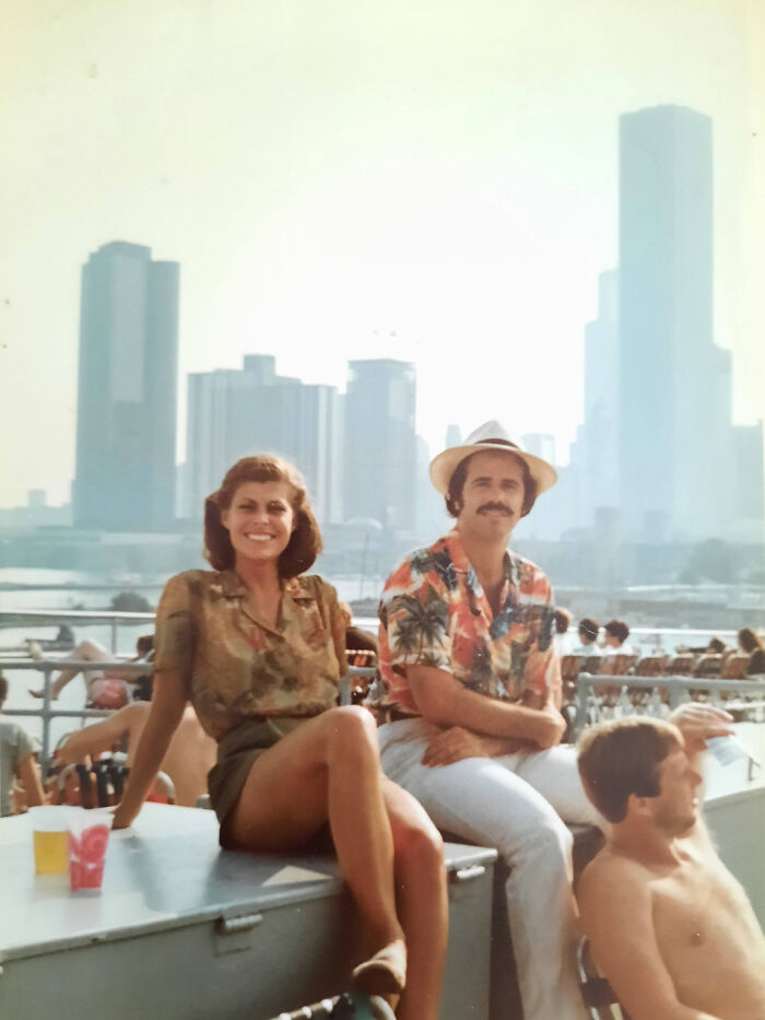 A couple in vintage attire with a city skyline behind them, capturing a beautiful old moment from the past.