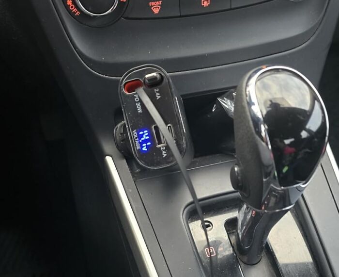 Car charger plugged in center console, featured in Amazon's spring sale.
