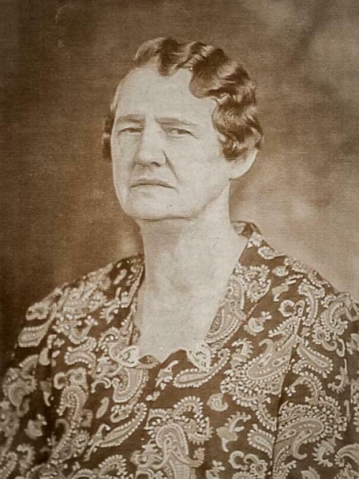 Retrato en blanco y negro de mujer con expresión seria, ropa con estampado paisley, foto antigua de hace décadas.