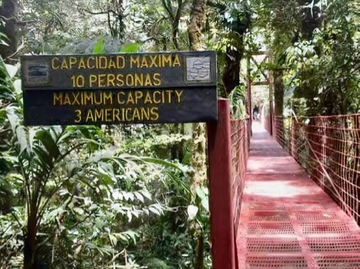 Bridge sign with incorrect capacity translation, allowing 10 people or 3 Americans.