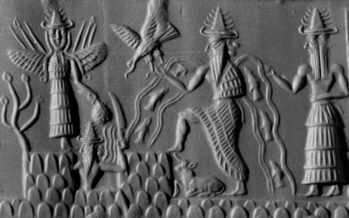 Ancient carved stone relief depicting triple threat deities with symbolic wings and ritual poses from early mythology.