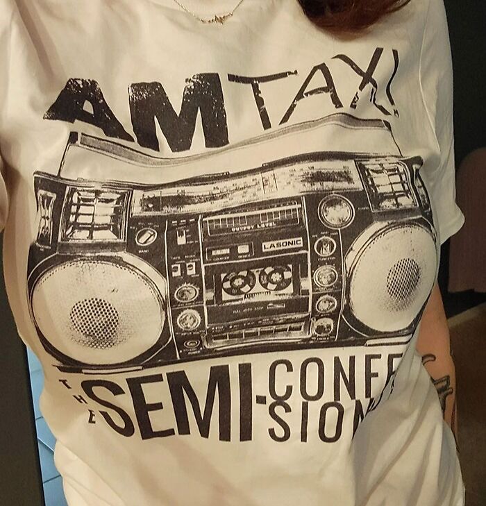 Person in an AM Taxi shirt with a boombox design, having a worse day than you.