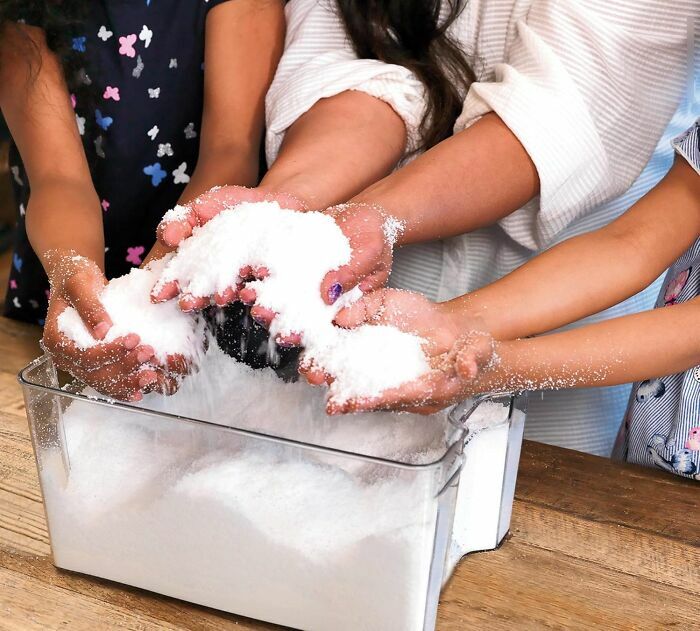 Children playing with a sensory toy involving a white granular material kids genuinely can't get enough of.