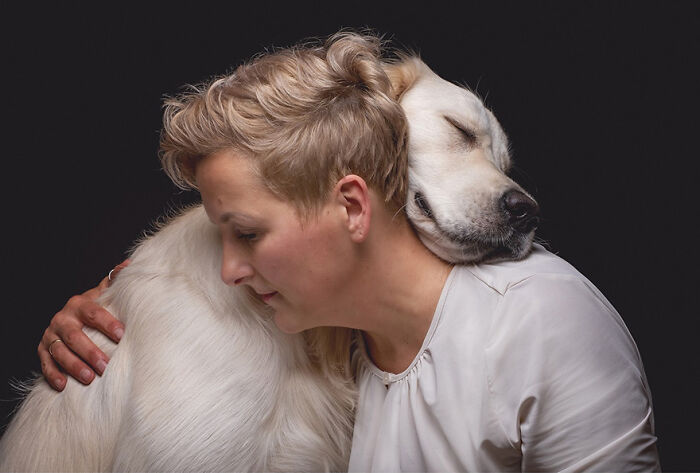 A person embracing a hunting dog, highlighting the connection and beauty captured in Elke Vogelsang's portrait photography.