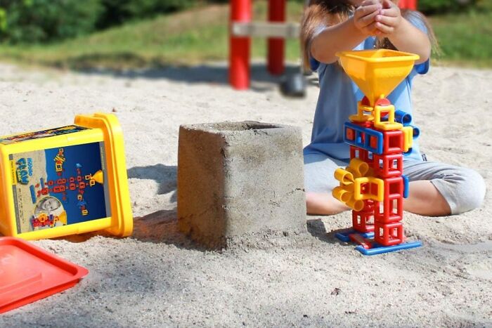 Child playing with colorful construction toy set in sandbox, one of the toys kids genuinely can't get enough of.