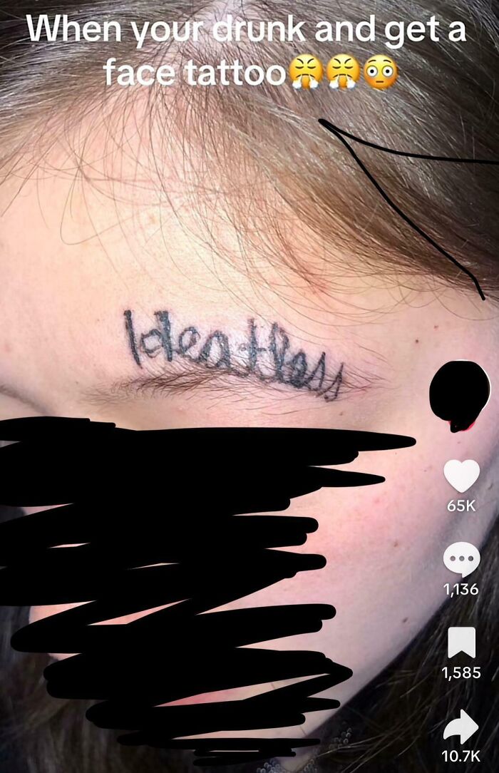 Close-up of a messy face tattoo with the word heartless misspelled, showing a wild tattoo fail on the forehead.