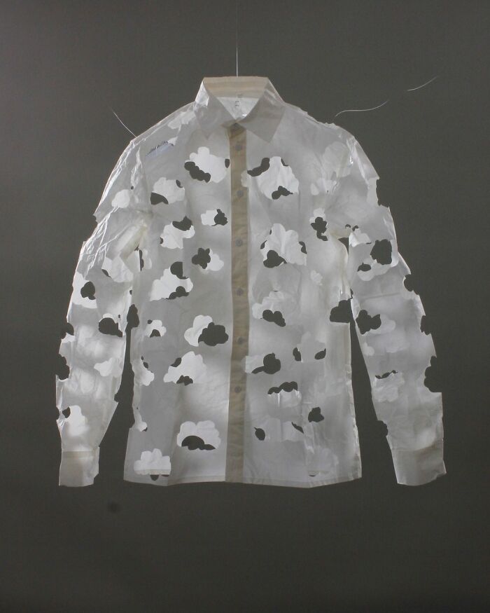 Paper art by Peter Callesen featuring a shirt with intricate cut-out designs resembling floating clouds.