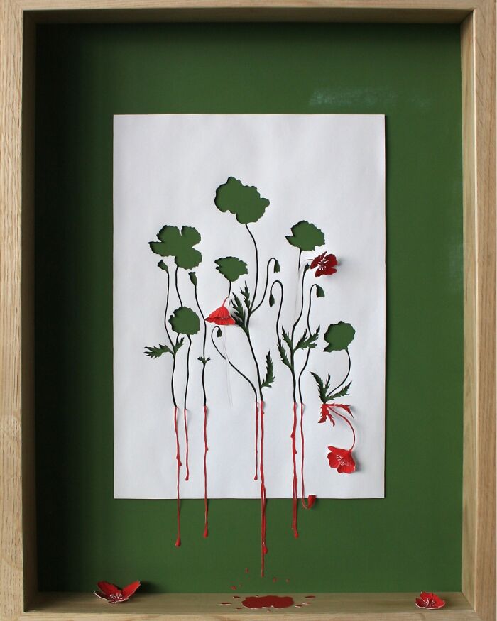 Paper art by Peter Callesen depicting flowers cut from white sheet with red petals on a green background.
