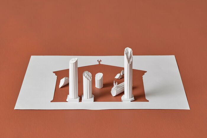 Paper mini world sculpture by Peter Callesen with columns emerging from a sheet.