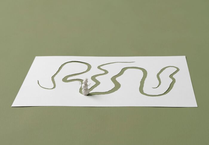 Miniature paper sculpture of a person and winding path crafted by Peter Callesen.