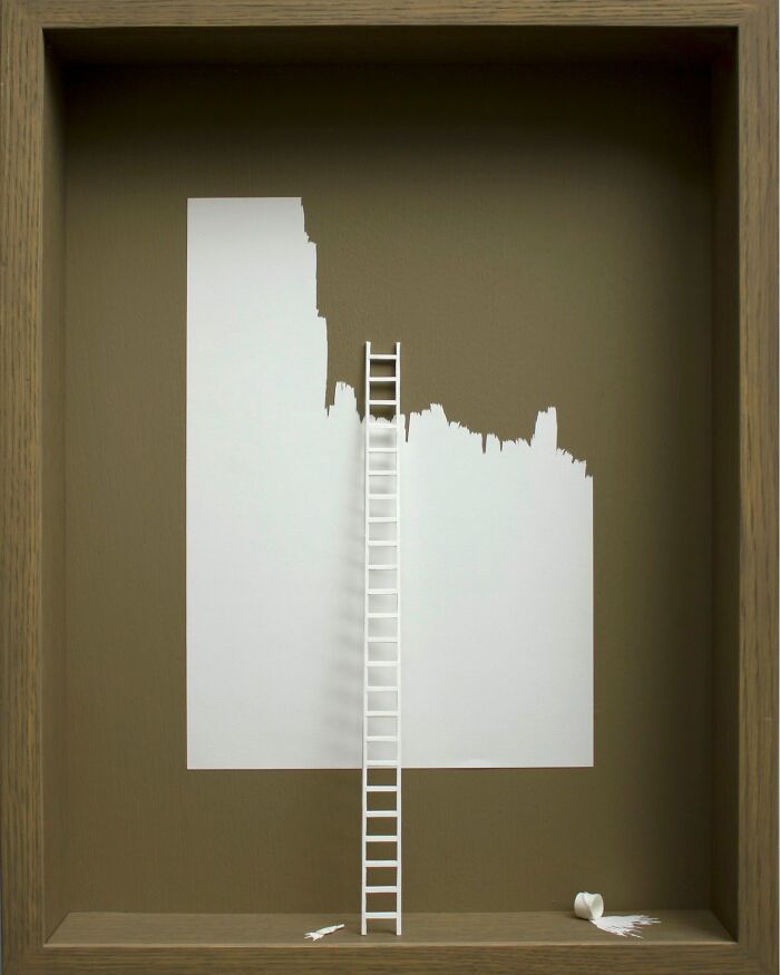 Paper art of a mini world with a ladder and torn sheet by Peter Callesen.
