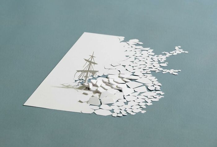 Paper mini world art by Peter Callesen, featuring a detailed ice ship scene crafted from white paper.