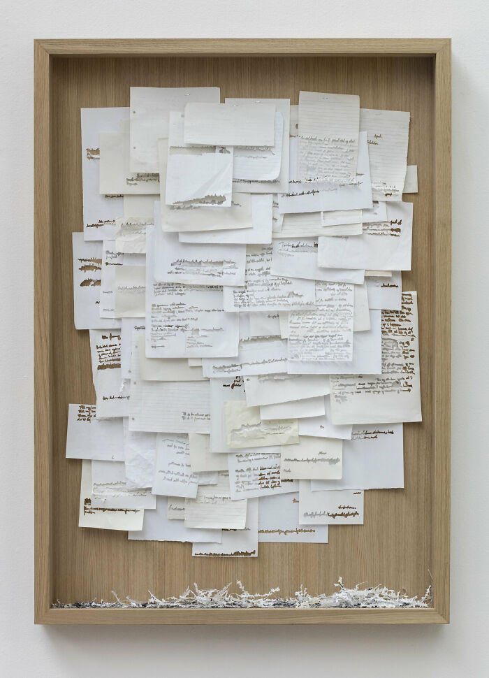 Paper art by Peter Callesen featuring a layered arrangement of cut paper sheets in a wooden frame.