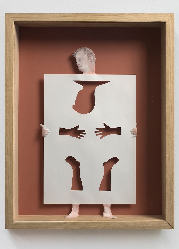 A unique paper artwork by Peter Callesen featuring a figure holding a cut-out sheet, within a framed display.