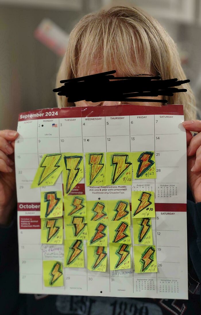 Person holding a September 2024 calendar covered with yellow lightning bolt sticky notes marking daily uplifting moments.