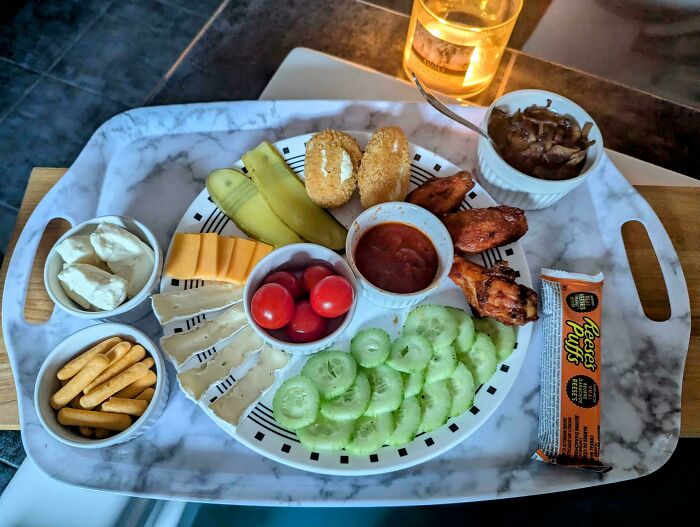 Tray with a pure and uplifting snack spread including vegetables, cheese, chicken wings, and dips for daily scroll inspiration.