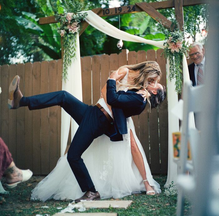 Pareja de recién casados en boda al aire libre, celebrando un momento positivo y conmovedor que inspira fe en la humanidad.