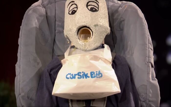 Cursik Bib product displayed on mannequin head in car seat, an example of Shark Tank products that completely flopped.