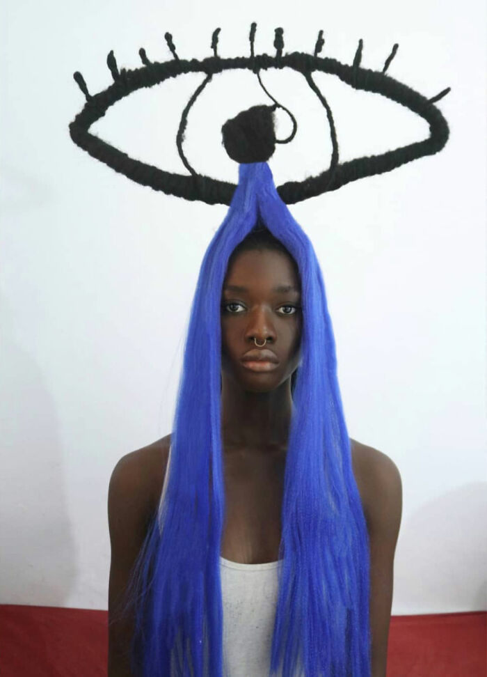 Artist's hair sculpture featuring vibrant blue hair and eye design.