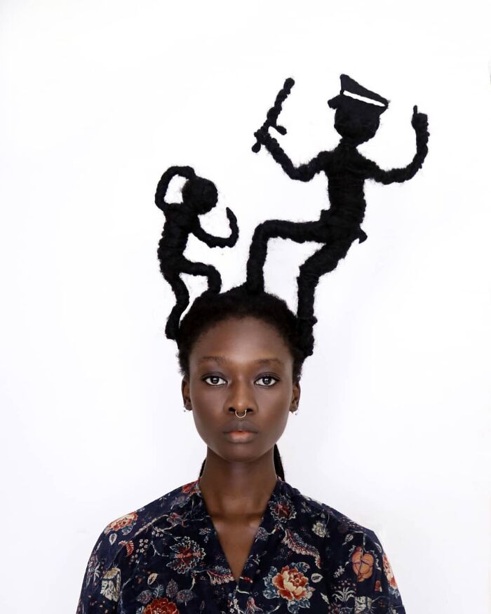 Artist's hair transformed into intricate sculptures featuring two figures with distinct poses.