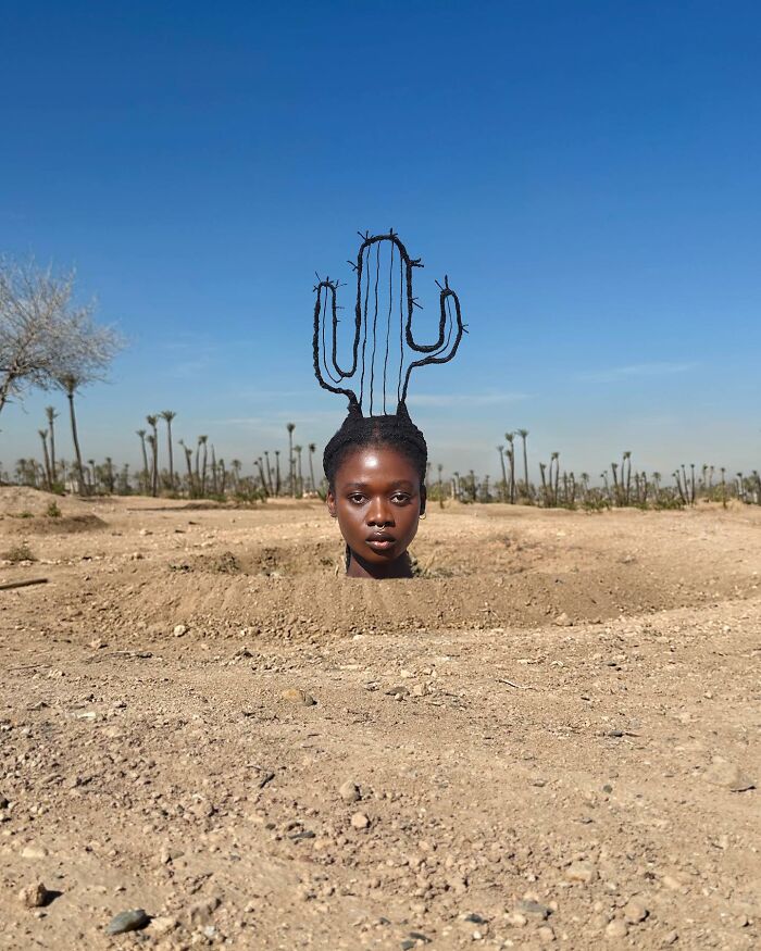 Woman in desert with cactus-shaped hair sculpture.