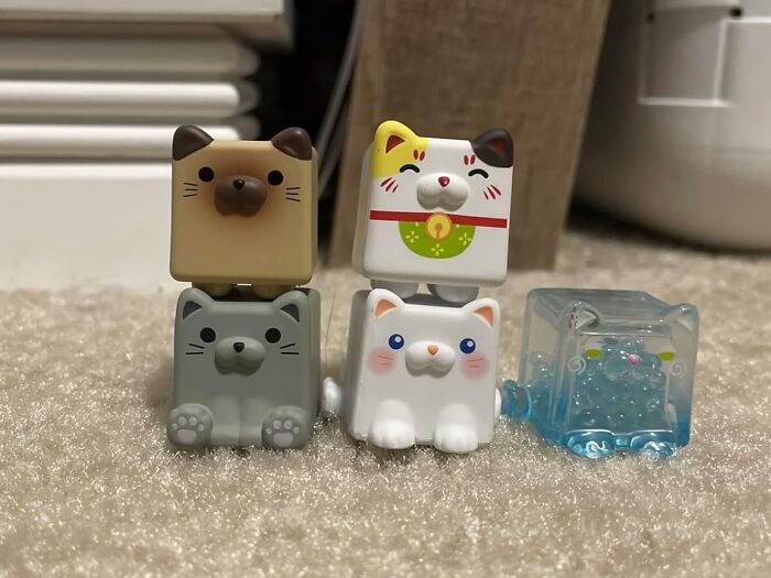 Stacked and colorful cat toys on a carpet, perfect playful items to unleash your inner child and spark joy.