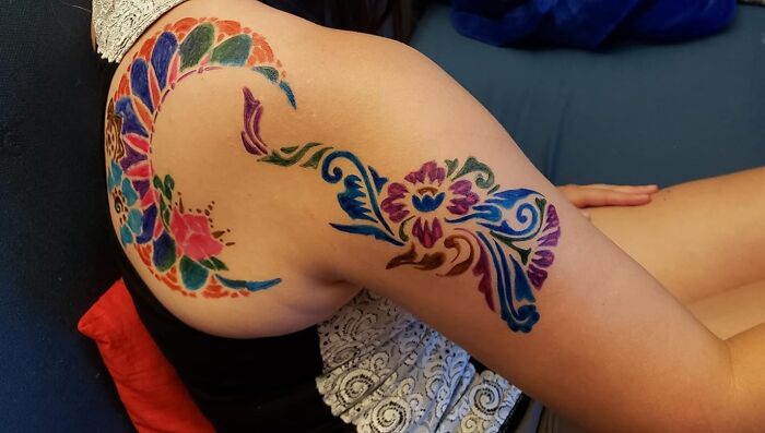 Colorful body art featuring a vibrant floral and abstract design, inspiring creativity and unleashing your inner child joy.