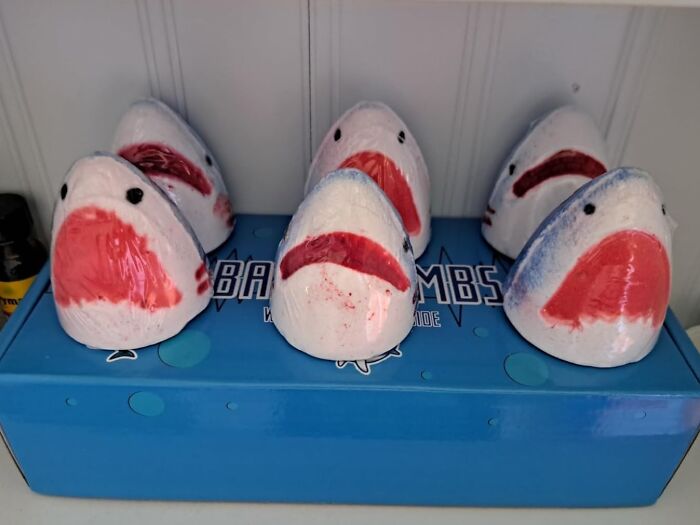 Ceramic shark figurines arranged on a blue box, playful items to unleash your inner child at any age.