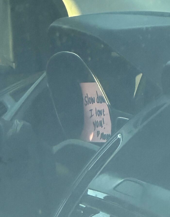 Handwritten love note saying slow down I love you on a car mirror, capturing pure and uplifting moments in daily life.