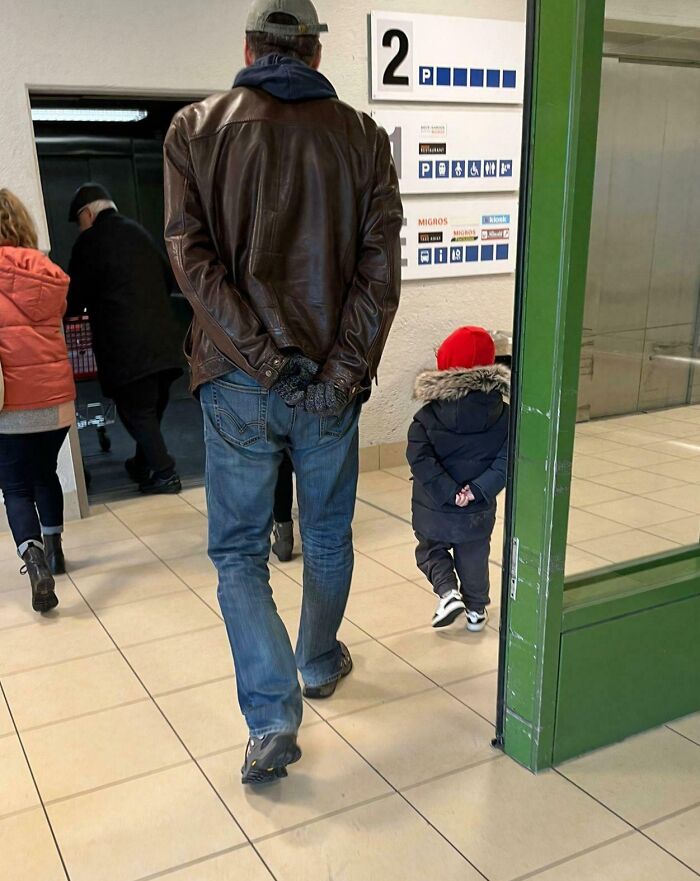 Hombre y niño caminando juntos en interior, mostrando momentos positivos y conmovedores para recobrar la fe en la humanidad.