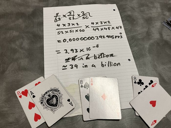 Probability calculation on paper showing rare card combinations, illustrating one-in-a-million coincidences with playing cards.