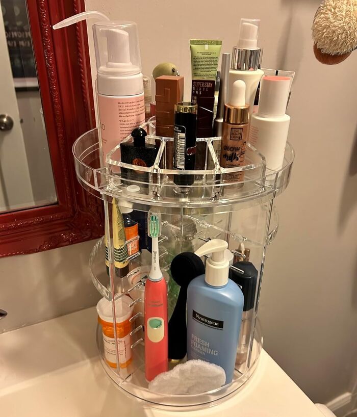 Clear rotating bathroom organizer holding toiletries and cosmetics, a genius organization find under $20 for home use.