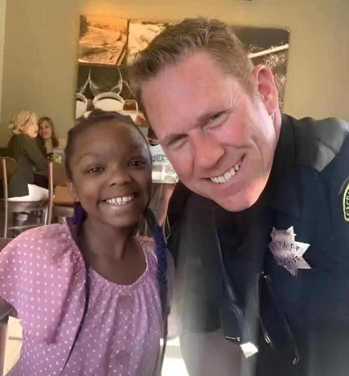 Child smiling with police officer in casual setting, capturing a heartfelt moment for "Forbidden Stories".
