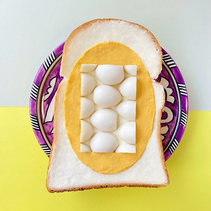 Creative toast design with layered eggs, styled on colorful plate.