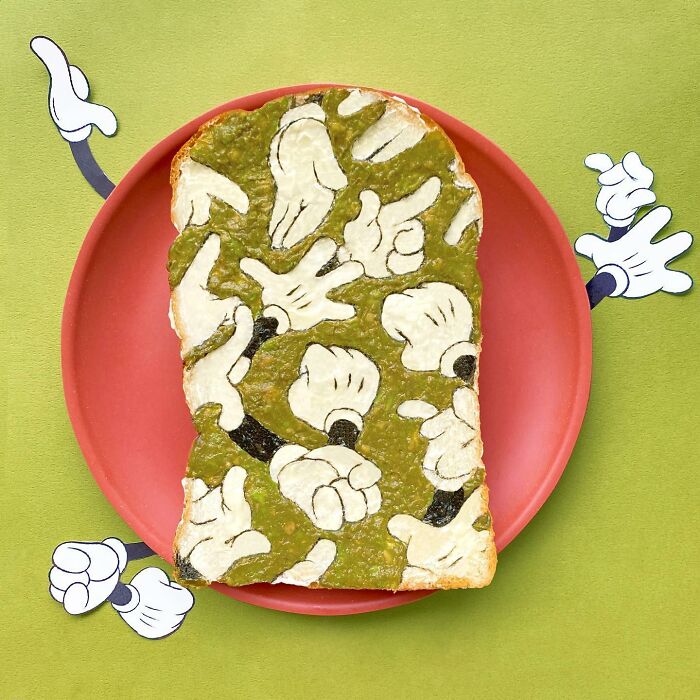 Creative toast design with cartoon hands by Japanese artist on a red plate.