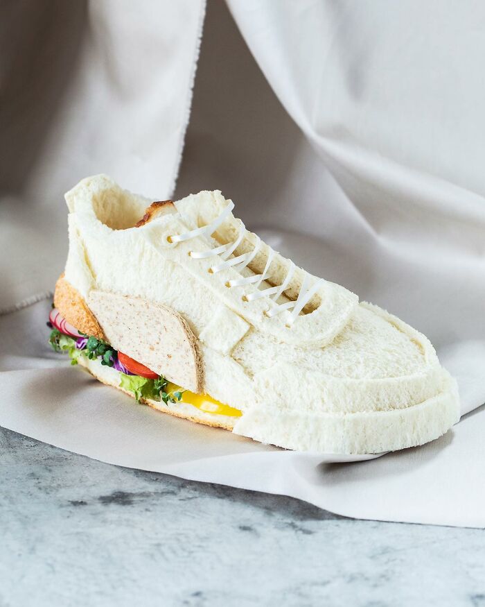 Creative toast design resembling a sneaker, made by a Japanese artist, featuring layers of bread and colorful ingredients.