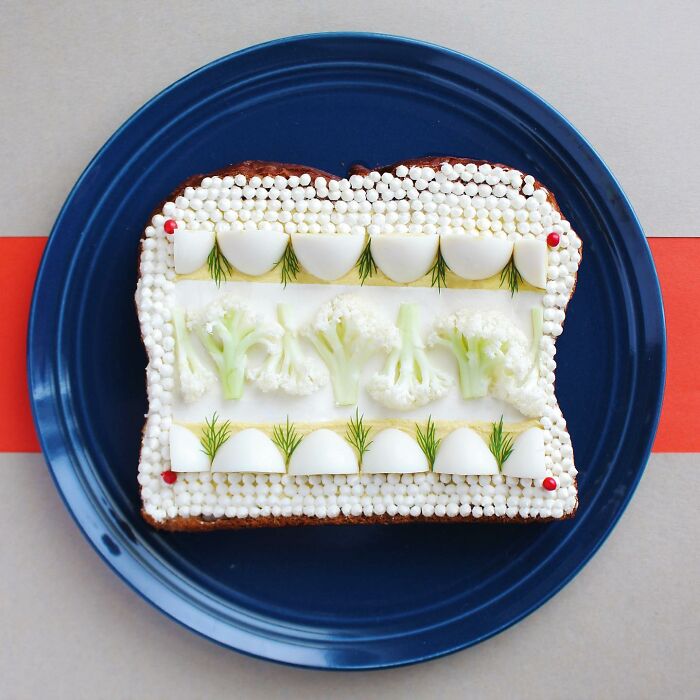 Creative toast design with cauliflower and egg patterns on a blue plate.