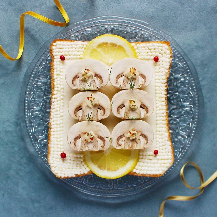 Creative toast design with mushrooms and lemon slices on a decorative plate.