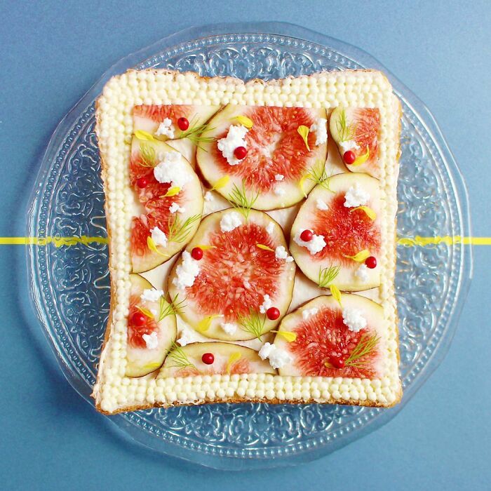 Creative toast design with figs, cream, and garnishes on a clear plate.