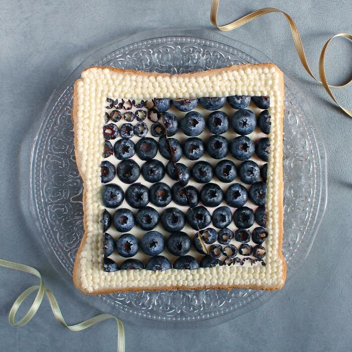 Creative toast design featuring blueberries on decorative bread by Japanese artist.