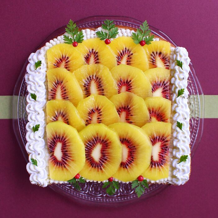 Creative toast design featuring vibrant fruit art with decorative garnishes on a clear plate.