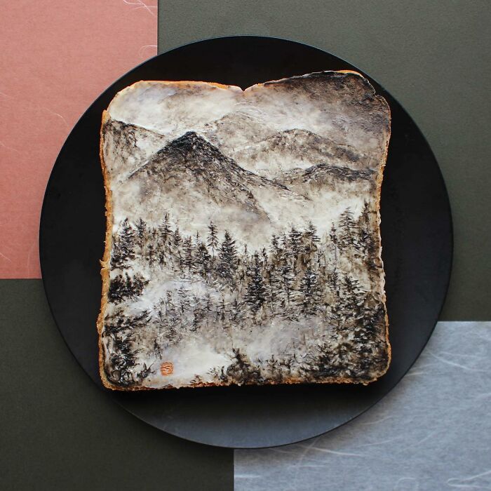 Creative toast design by a Japanese artist, depicting a landscape with mountains and trees on a square slice of bread.