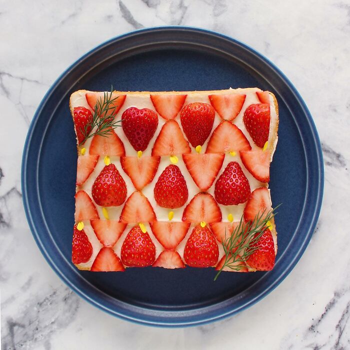 Creative toast design with strawberries and dill on a blue plate by Japanese artist.
