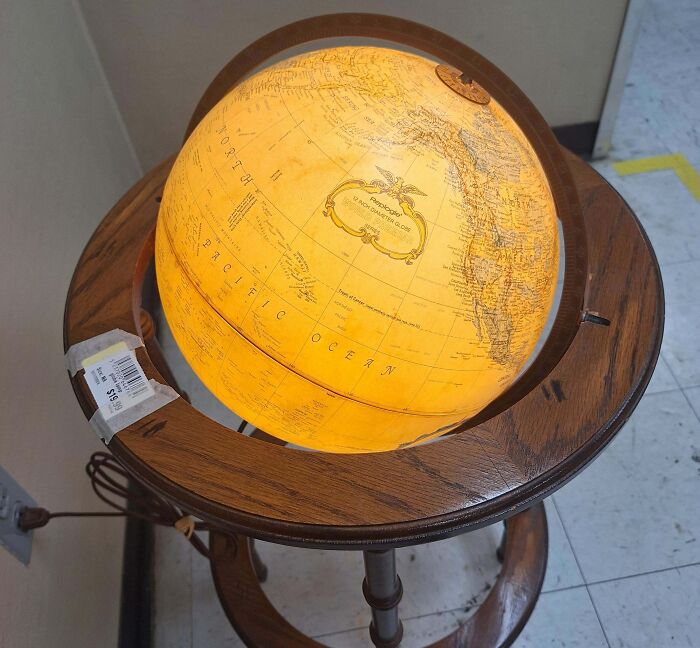 Illuminated vintage globe on a wooden stand, a hidden gem found at Goodwill.
