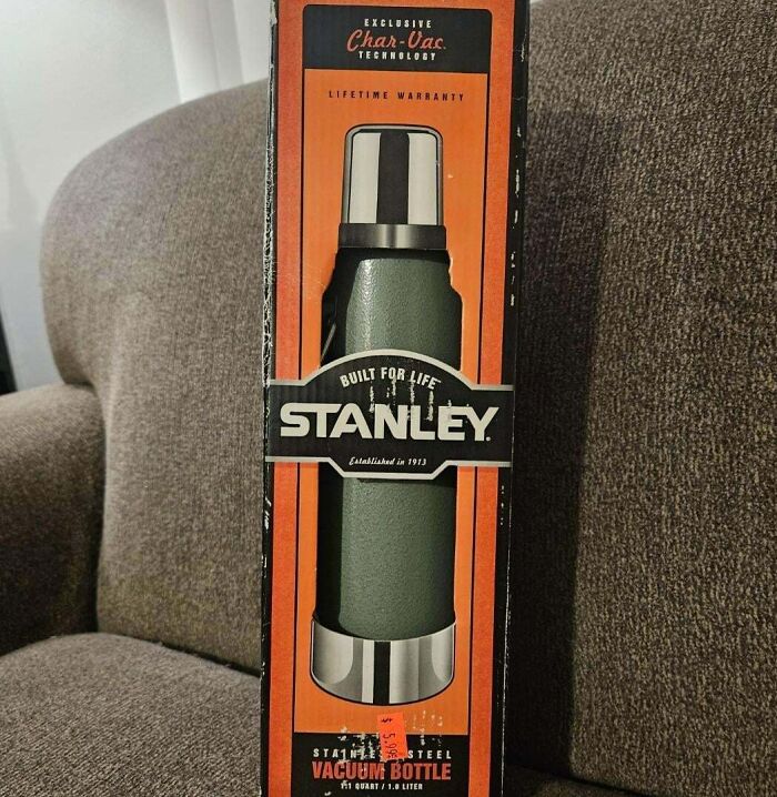 Stanley vacuum bottle in box, a thrift store gem found at Goodwill, resting on a brown sofa.